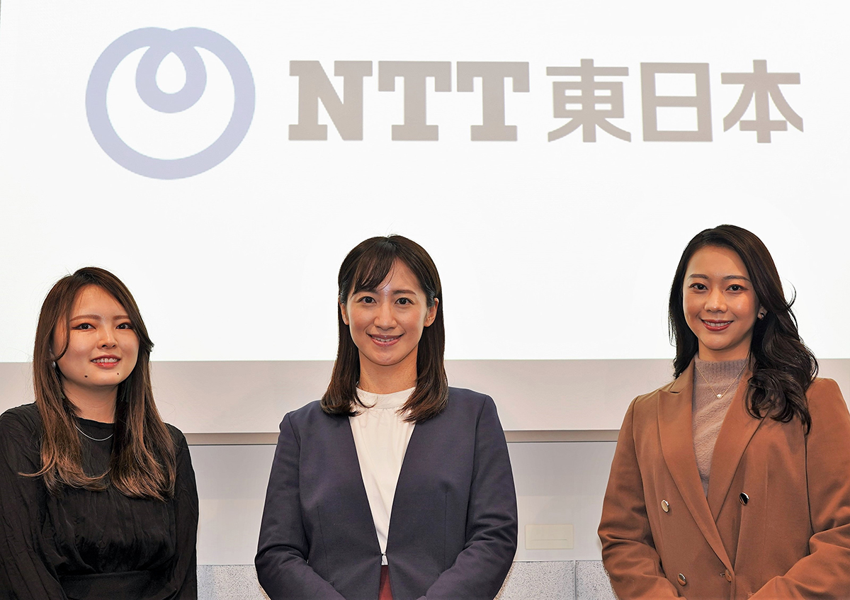 NTT東日本会社ロゴを背景にするプロモーショングループの3人